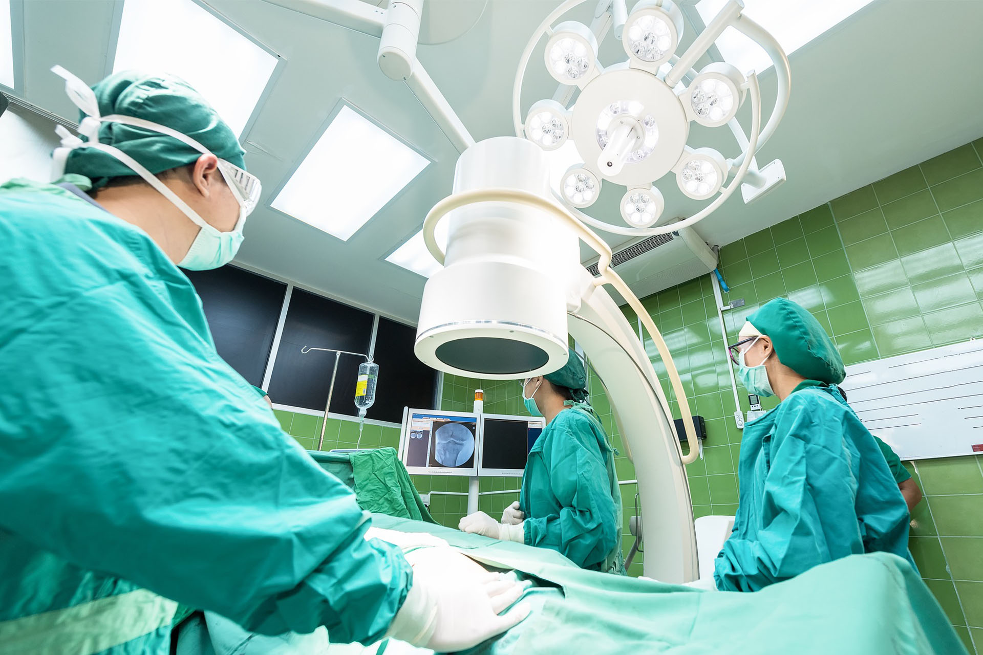 Surgeons and surgical technologists in an operating room.